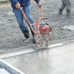 Workers finishing a freshly poured concrete slab