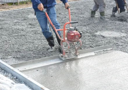 Workers finishing a freshly poured concrete slab
