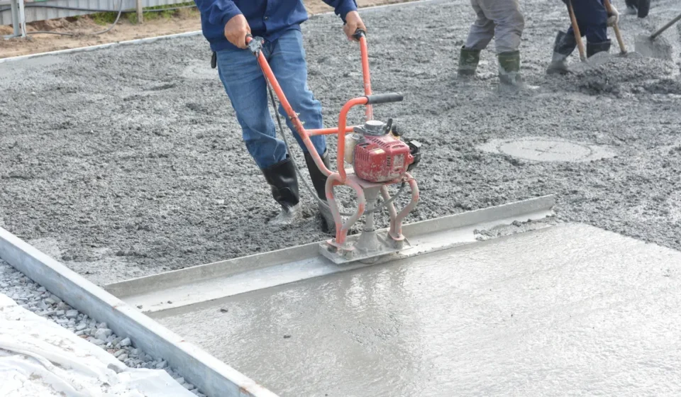 Workers finishing a freshly poured concrete slab