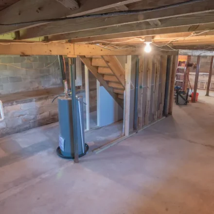 unfinished basement with exposed framing and concrete slab