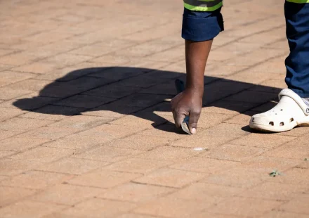Worker inspecting a paved driveway surface