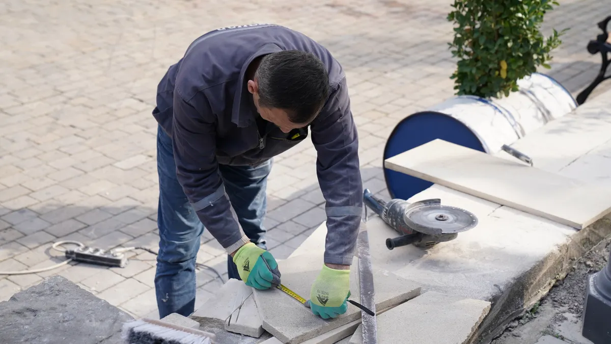 Can You Level a Porch Slab With Attached Steps? Worker cutting damaged concrete slabs