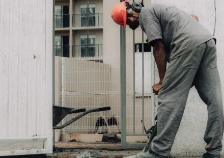 Worker breaking concrete beside a doorway