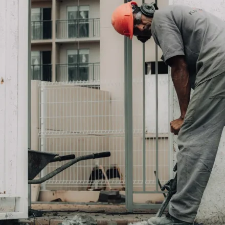 Worker breaking concrete beside a doorway