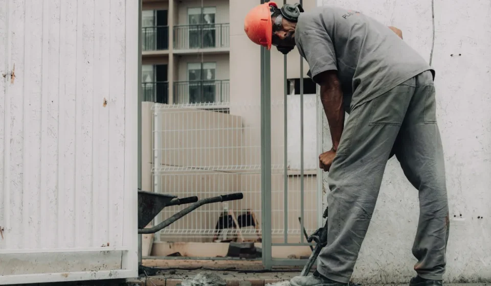 Worker breaking concrete beside a doorway
