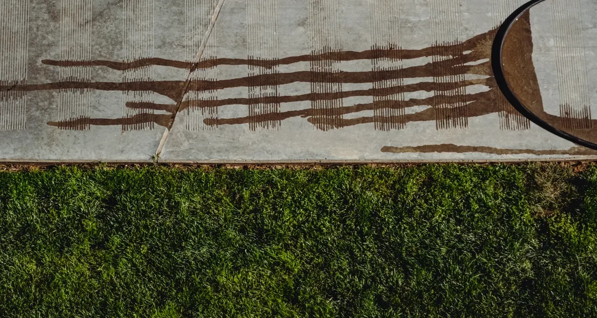 Concrete slab edge beside lawn with staining