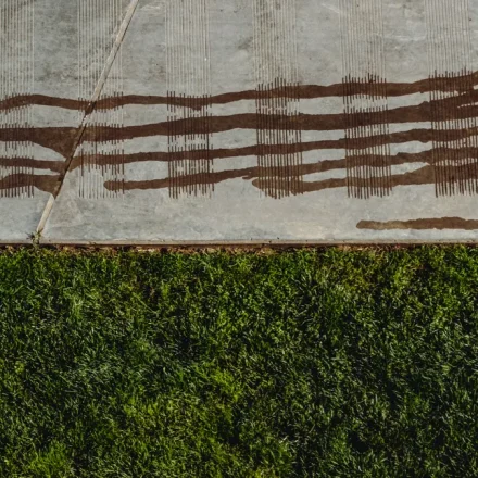 Concrete slab edge beside lawn with staining