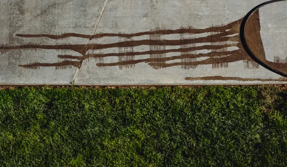 Concrete slab edge beside lawn with staining